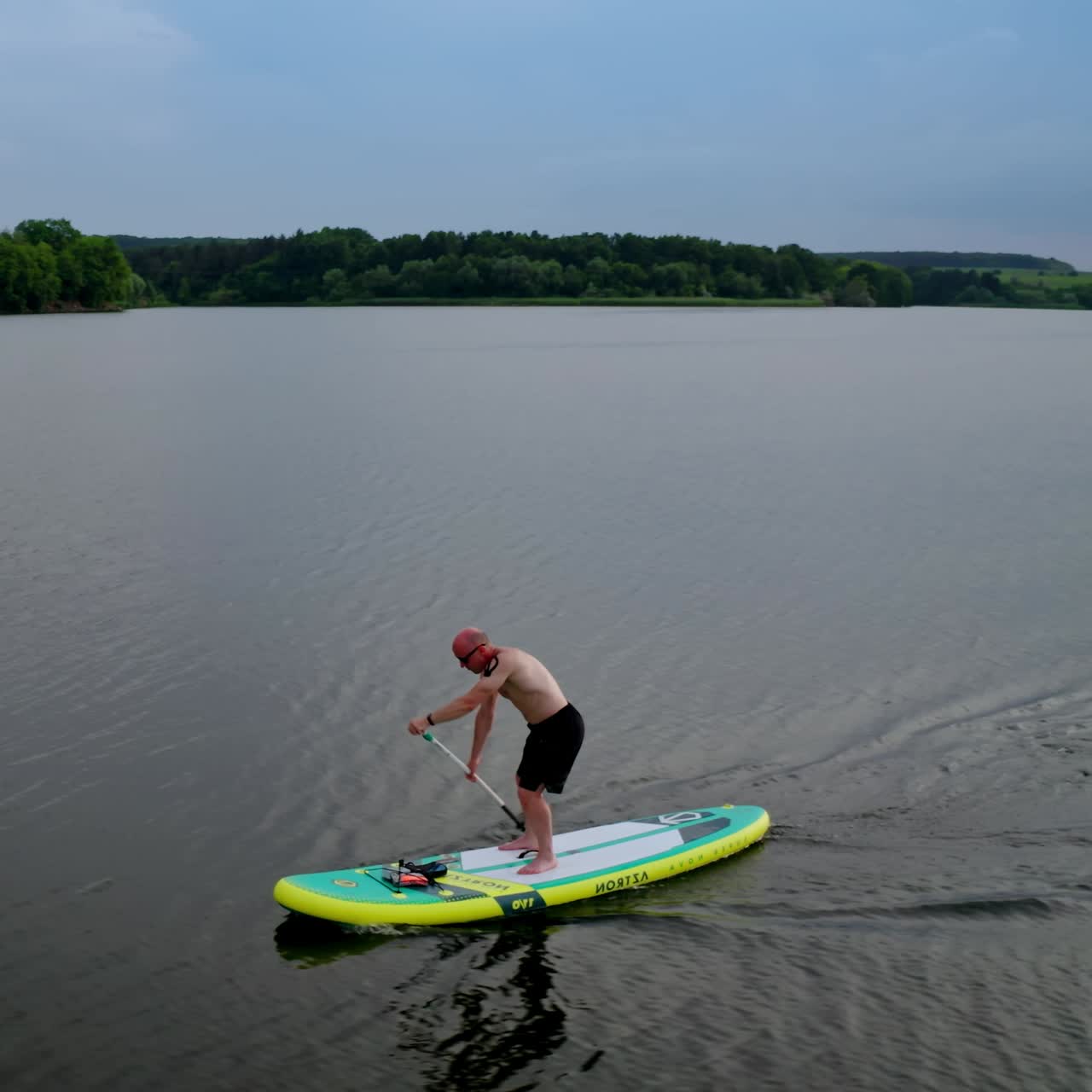 Man standing on sup board. Handsome young man on sup paddle standing board