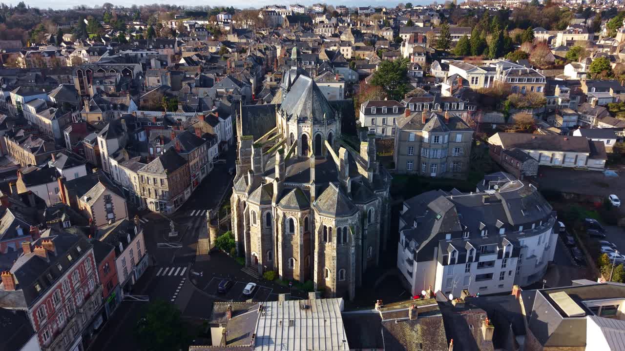 Un drone si avvicina alla basilica di Notre-Dame-des-Miracles, rivelando la città di Mayenne che la circonda