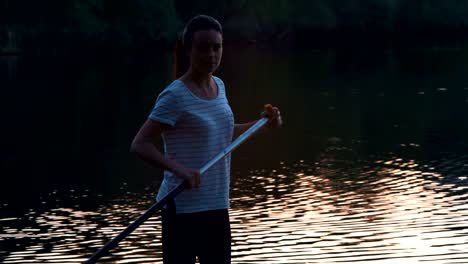 disparo medio, hermosa niña flota de pie en sup y filas por remos