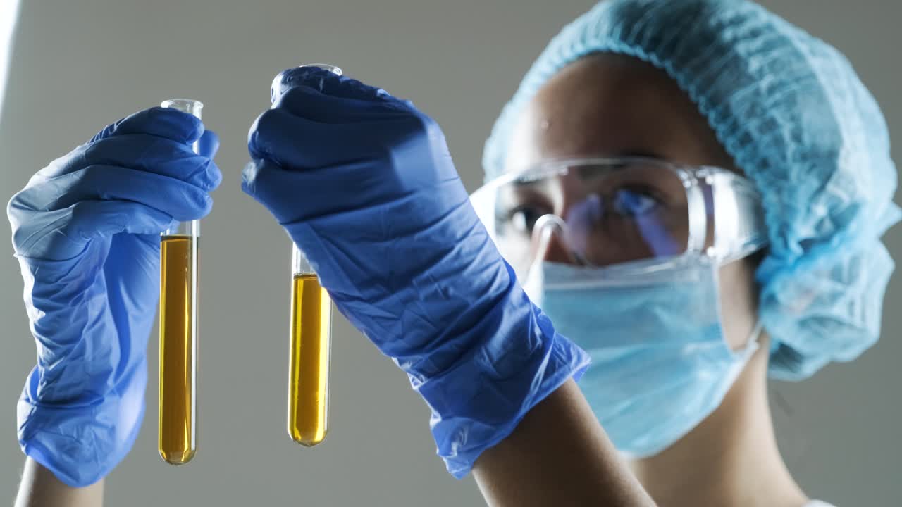 실험실 에서 실험 튜브 를 검사 하는 과학자