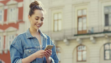 linda chica caminando y enviando mensajes de texto en el teléfono inteligente