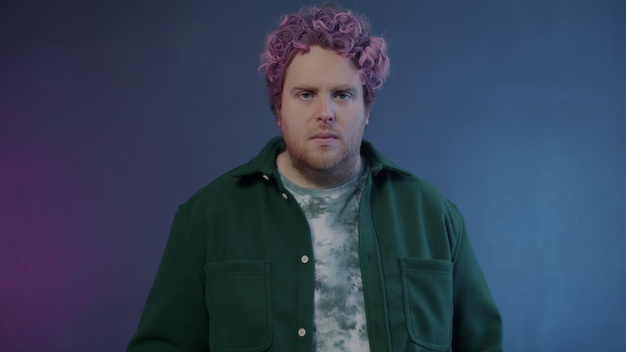 Man with pink hair in a green jacket