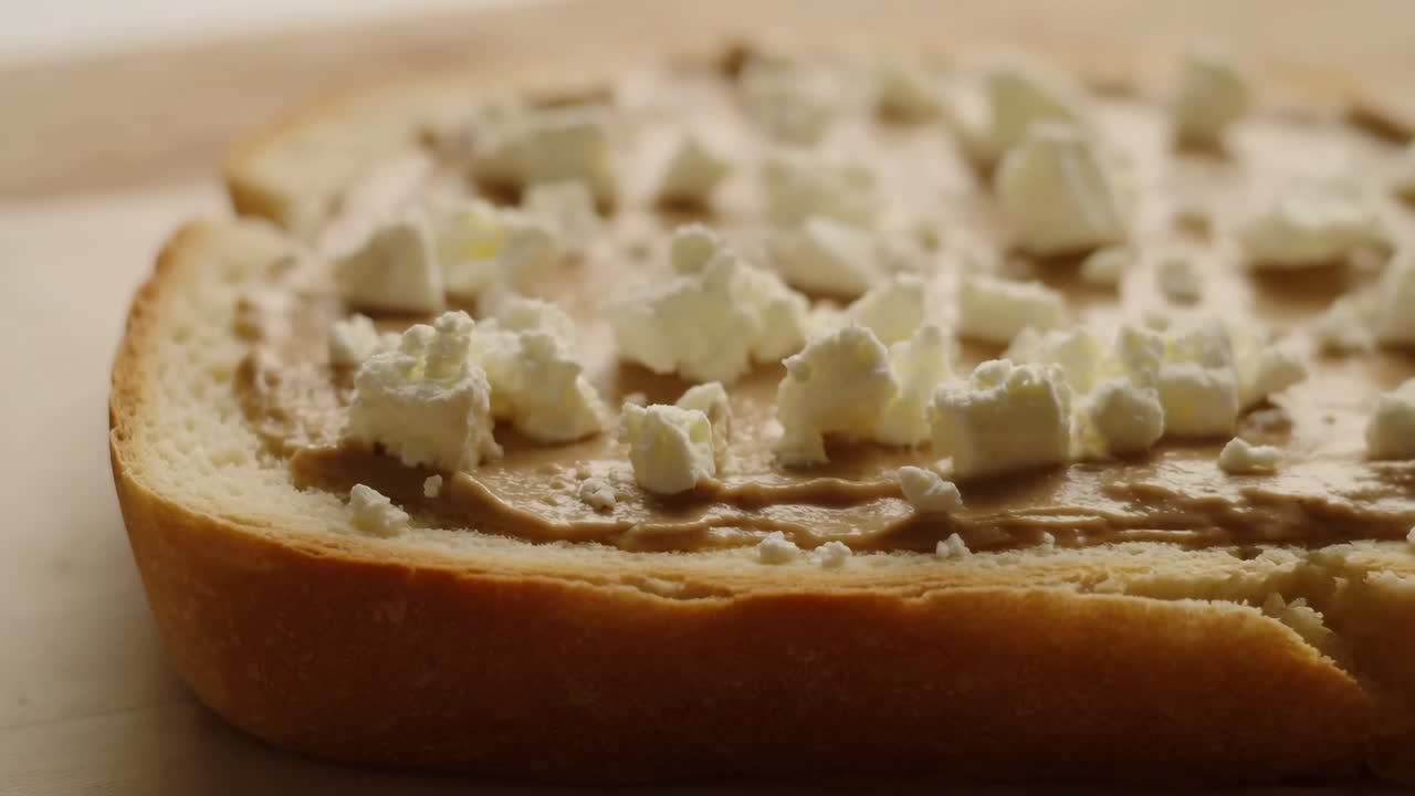 Primo piano di fetta di pane con burro di arachidi e formaggio feta