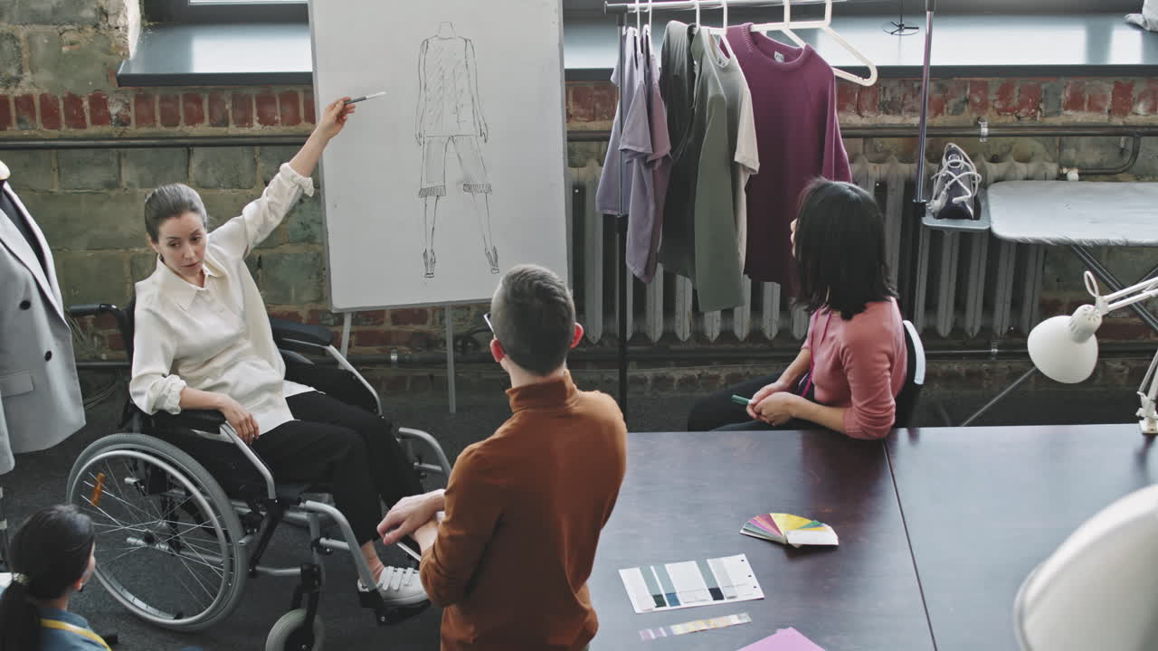 여성 패션 디자이너가 팀과 만나고 있습니다.