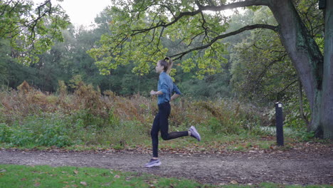 captivating side-tracking shot: camera glides backward as woman runs alongside, showcasing her graceful movement in serene surroundings