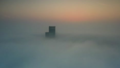 foggy sunrise over city skyscraper