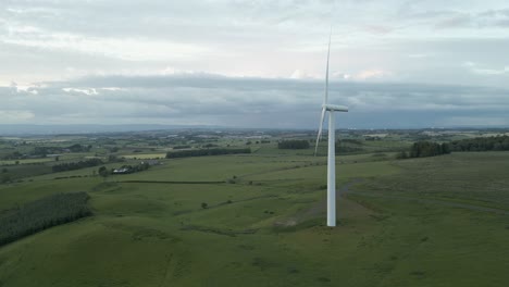 Aufsteigende-Antenne-Neigt-Horizont-über-Einsame-Windturbine,-Die-Sich-Im-Land-Dreht