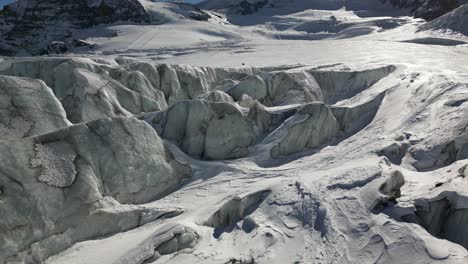 Aerial-push-in:-glacier-with-relief-and-crevasses,-winter-snowy-landscape