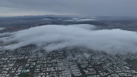 aerial shot of drone flying over city in cloudy day