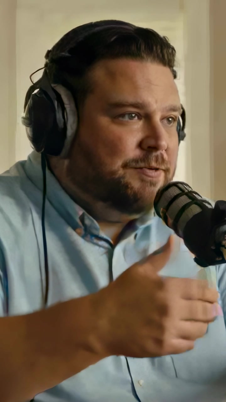 Vertical video: Starting recording host wearing blue shirt using headset speaking into mic at home