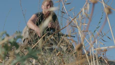 ranger female soldier taking his weapon from the floor