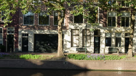 looking on buildings along the lage gouwe street across the canal in gouda, netherlands