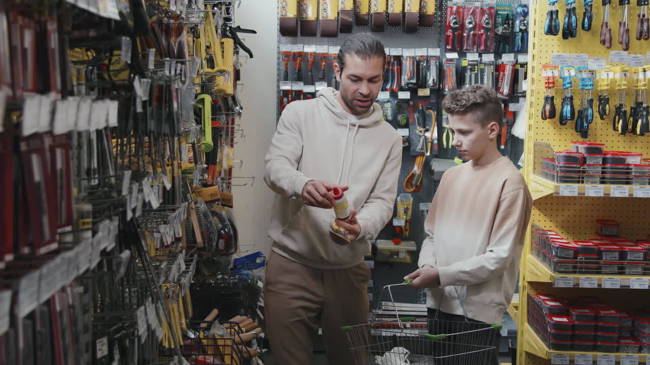 Father and Son Choosing Supplies at Home Improvement Store