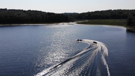 boat tows tube on the lake in the pocono mountains during golden hour