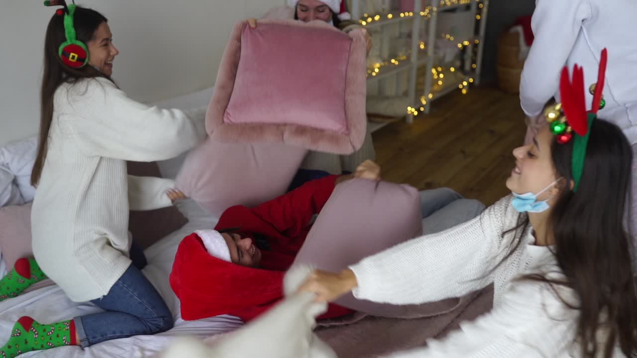 amigos haciendo una pelea de almohadas de navidad.