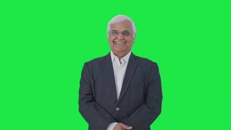 Happy-Indian-senior-journalist-smiling-Green-screen