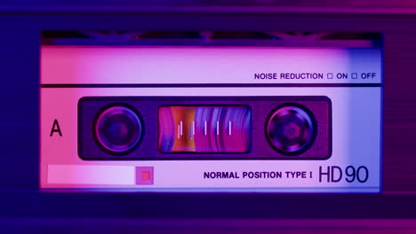 close-up of a vintage audio cassette with neon lighting