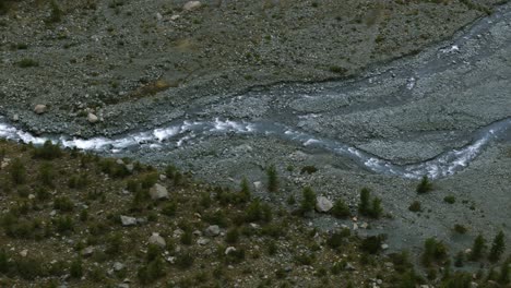 Water-stream-flowing-on-dry-mountain-river-bed-in-Alpe-Ventina-of-Valmalenco-in-Northern-Italy