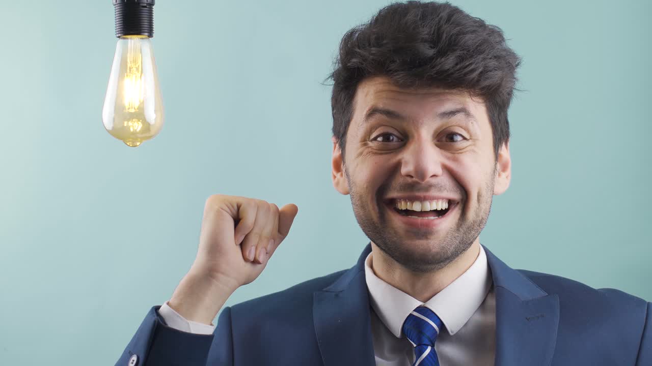 el joven empresario inteligente encuentra nuevos inventos, ideas y la lámpara de la idea se enciende.