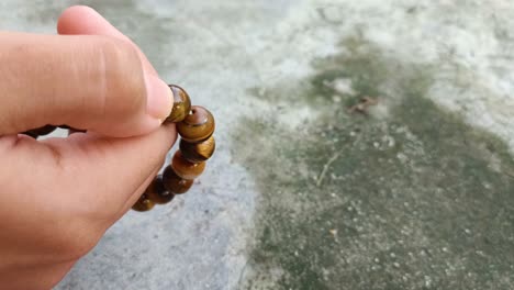 close up of hands praying rosary or prayer beads