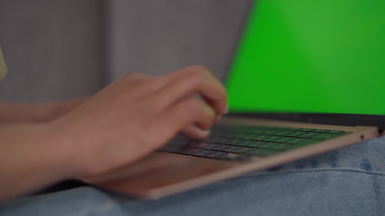 primer plano de manos femeninas afroamericanas escribiendo en el teclado de la computadora portátil con pantalla verde. desconocido joven experto profesional mensajería en línea navegación por internet en el dispositivo chromakey en la oficina de casa.