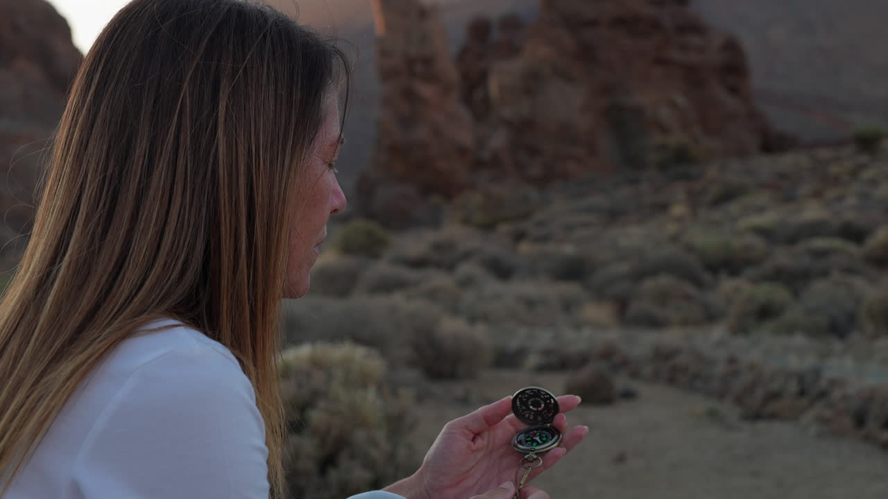 Tourist woman checking compass in Teide National Park, Tenerife, Canary Islands, Spain