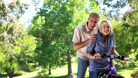 Pareja-Feliz-Posando-Con-Una-Bicicleta-En-El-Parque