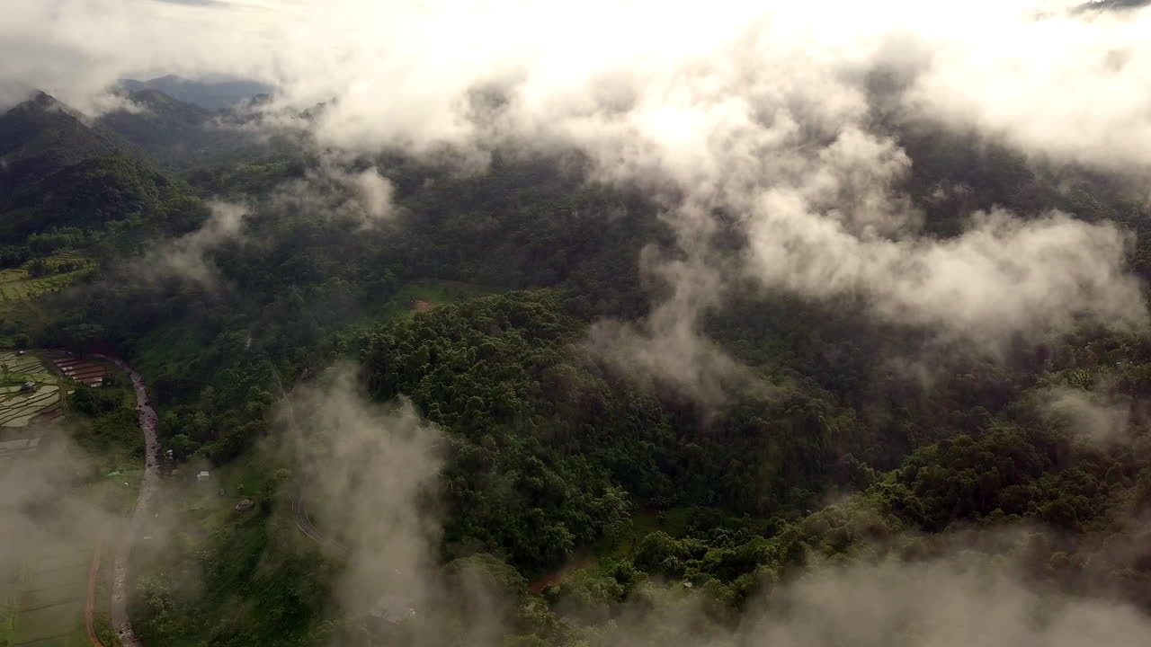 vista aérea volando a través de la mañana lluvia cubierta de nubes selva tropical paisaje montañoso durante la temporada de lluvias en el parque nacional reservado de la montaña doi phuka el norte de tailandia