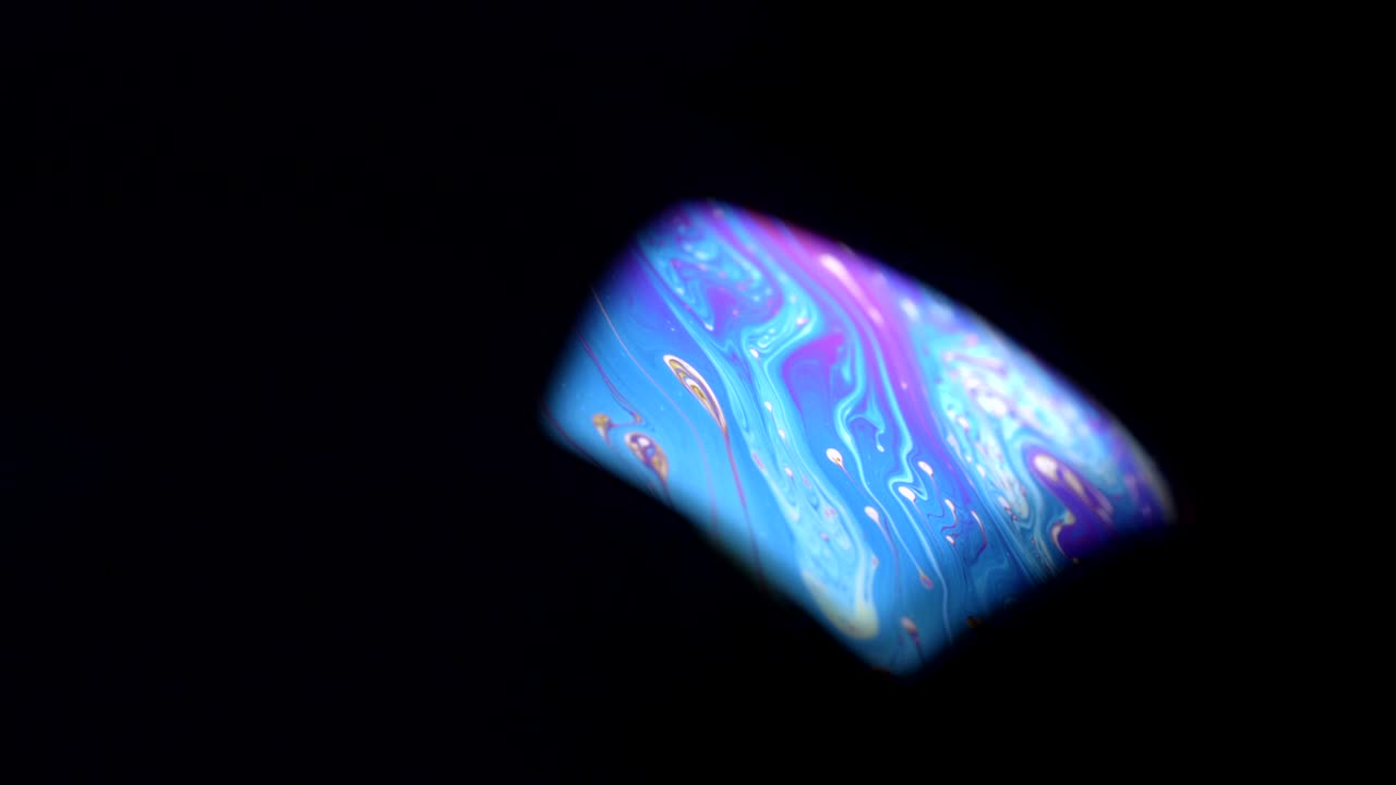 밝은 색의 거품이 빛 속에서 움직입니다.