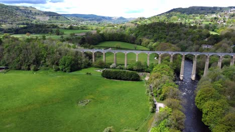 aerial view pontcysyllte aqueduct and river dee canal narrow boat bride in chirk welsh valley countryside descending tilt up reveal