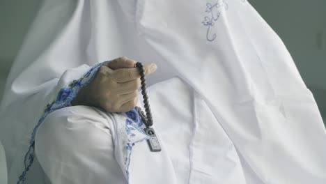 muslim senior woman hand with prayer beads