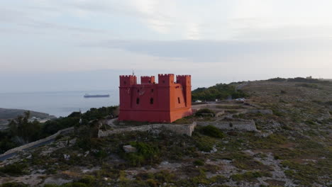 Drone shot flying around the St Agatha&#039;s Red Tower, sunny evening in Malta