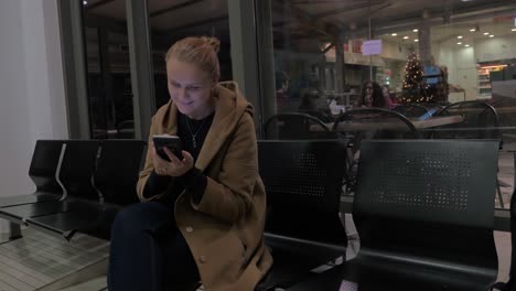 Smiling-woman-using-mobile-in-shopping-centre