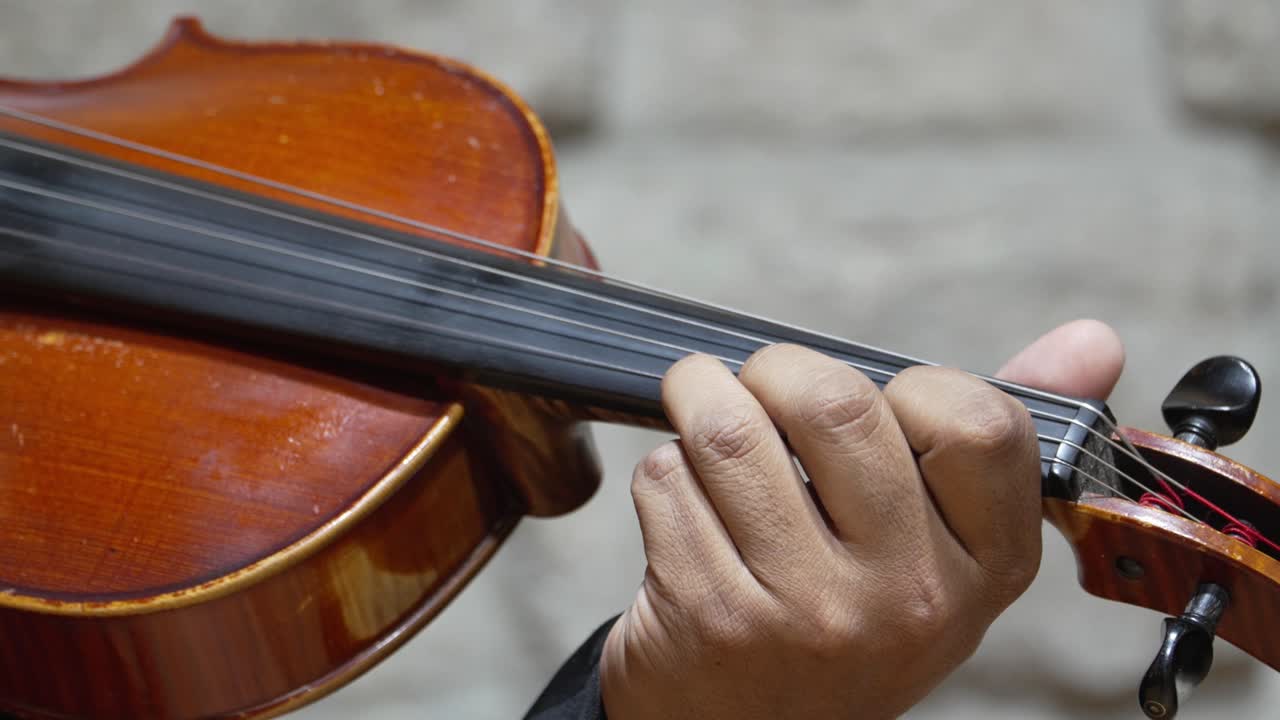 la mano y los dedos del violinista en la pizarra del violín tocando música, primer plano de la habilidad del músico