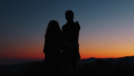 silhouette of romantic couple pointing to the sky