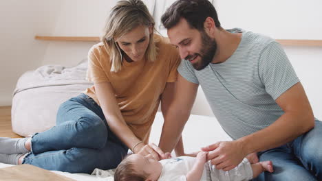 Liebevolle-Eltern-Mit-Neugeborenem-Baby,-Das-Zu-Hause-In-Der-Loft-Wohnung-Auf-Dem-Bett-Liegt