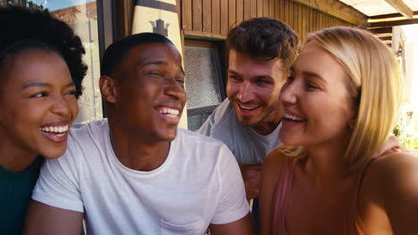 pov shot of smiling multi-cultural friends outdoors at home posing for selfie on mobile phone