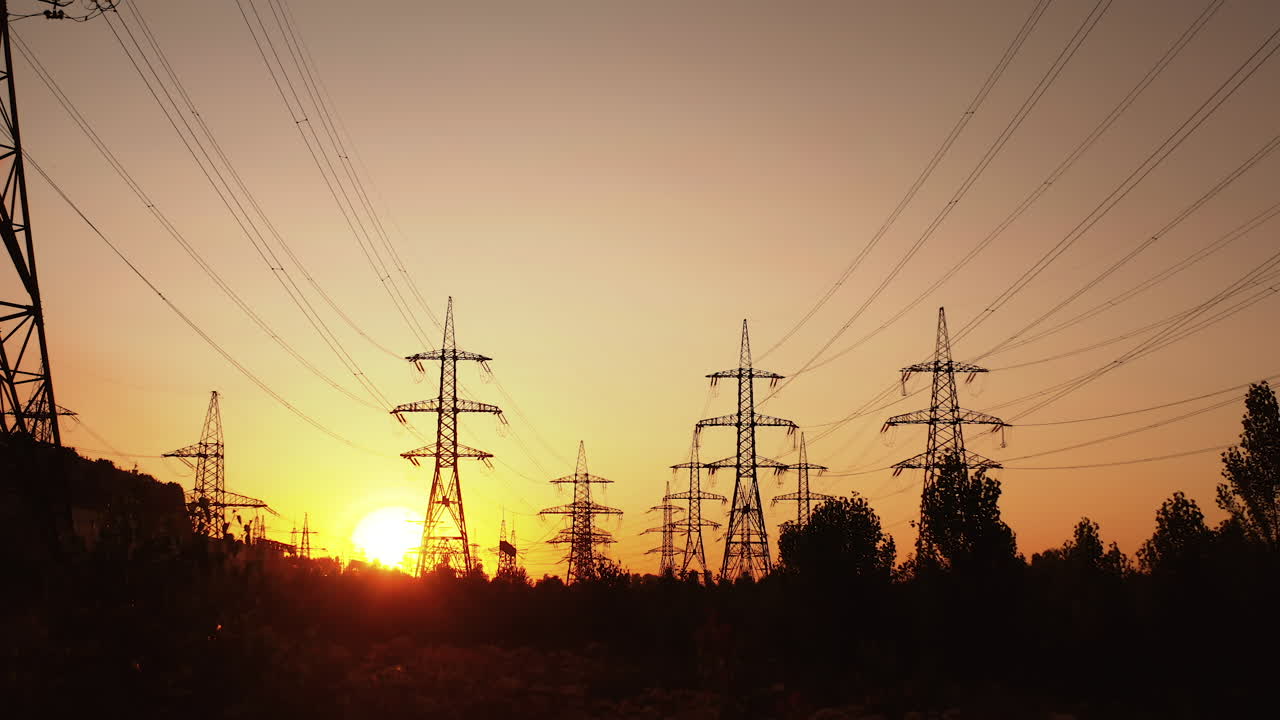 Technogenics landscape, urban. The energy of the pole in the rays of the rising sun. Posts for the transfer of high lead. Steel electric pillars concept