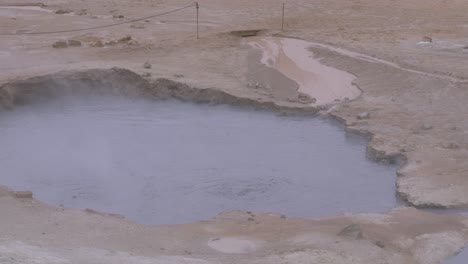 boiling water in a steaming hot spring surrounded by rocky ground in iceland's namaskaro region