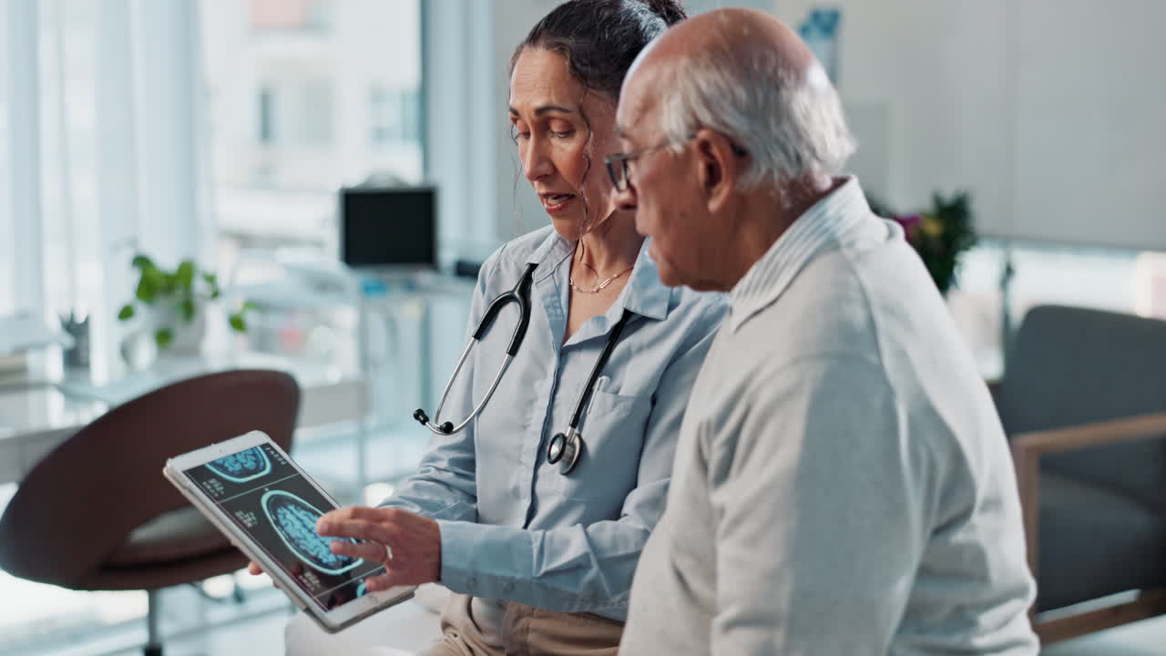 Doctor showing brain scan to patient on tablet