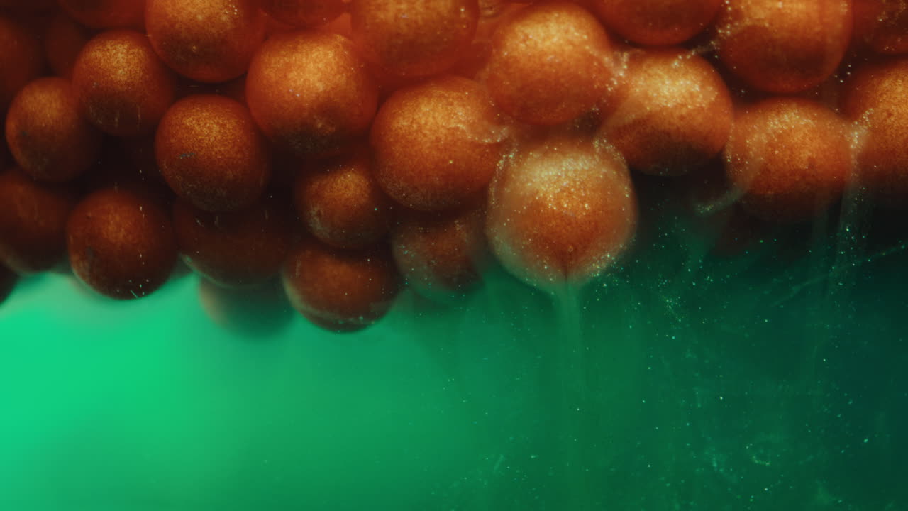 Abstract Macro Photography of Orange Spheres in Green Liquid