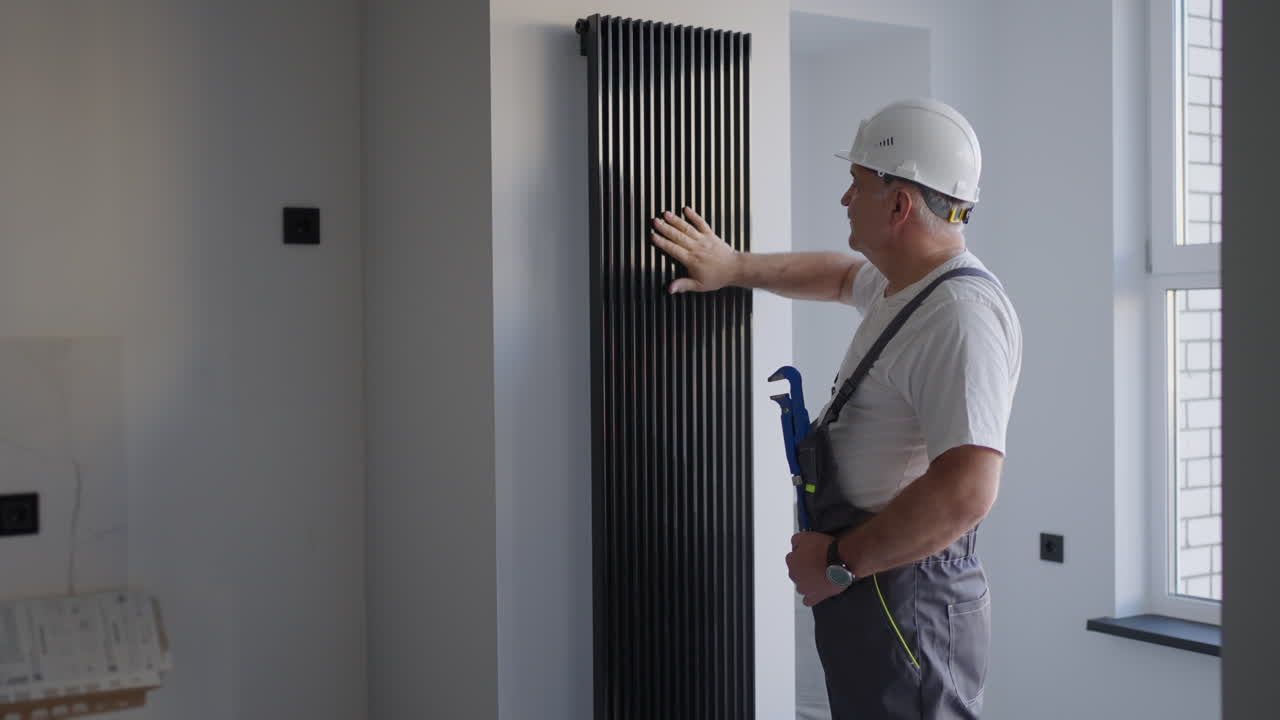 A man plumber checks the batteries and heating system. Heating season