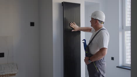 a man plumber checks the batteries and heating system. heating season