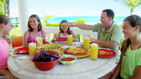 familia caucásica comiendo en la cubierta de un hotel de playa de vacaciones