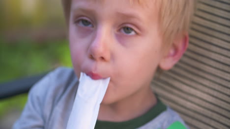 Ein-Süßer,-Kleiner,-Blonder-Junge,-Der-An-Einem-Heißen-Sommertag-Ein-Freezie-Genießt