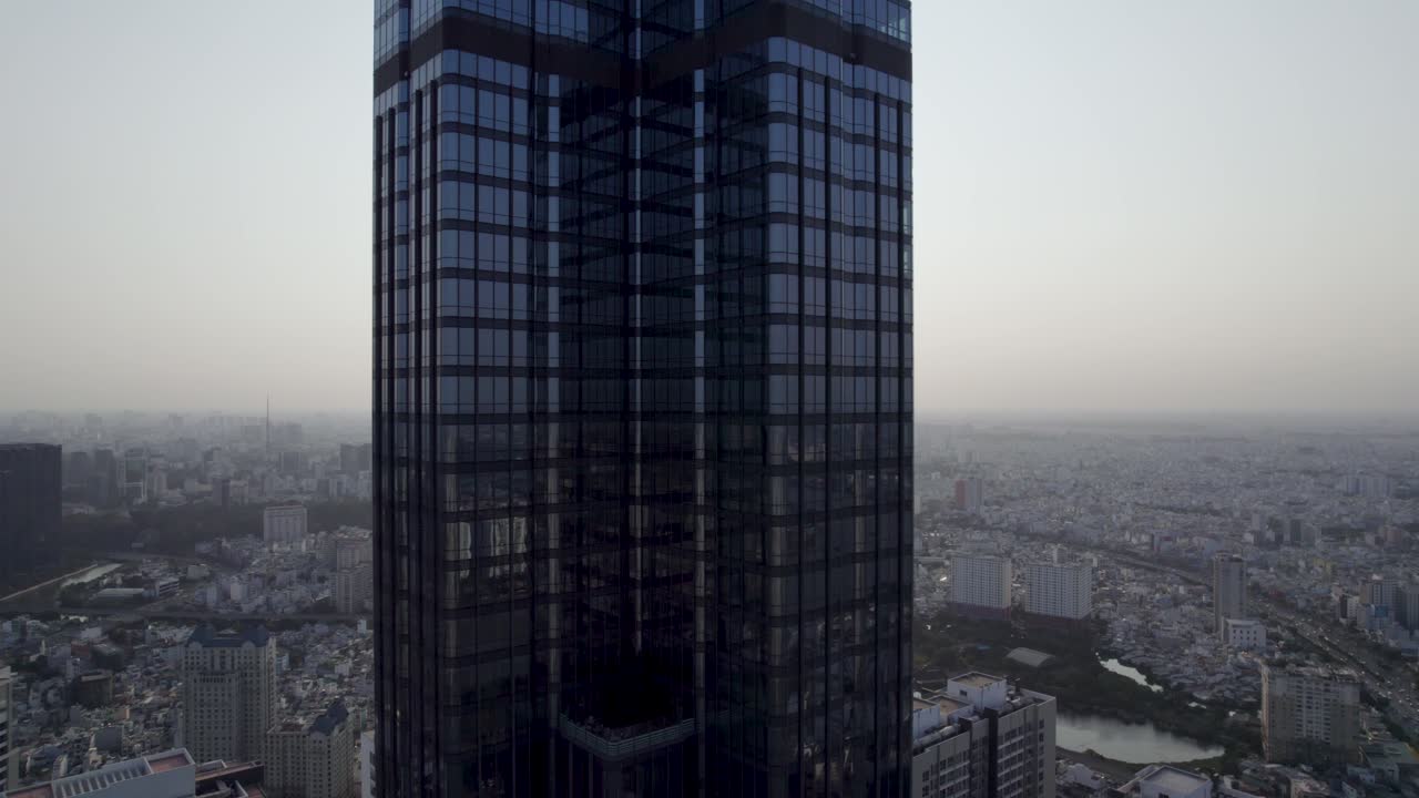 primer plano del edificio histórico 81 en la ciudad de ho chi minh, saigón, la torre más alta de vietnam durante la puesta de sol con reflejo de vidrio - video de avión no tripulado descendente