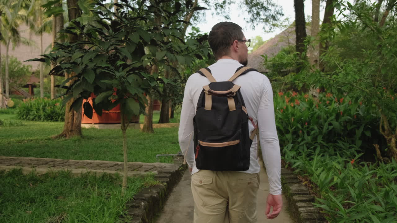 Traveler walking through a tropical garden