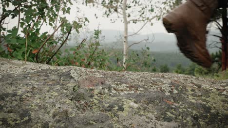 Close-up-of-a-female-hiking-boot-climbing-up-a-rock-outdoors-in-the-mountains