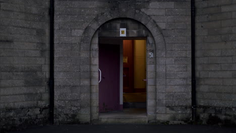 Puerta-Abierta-Del-Edificio-De-Bloques-De-Cemento-En-Una-Noche-Oscura-Y-Espeluznante