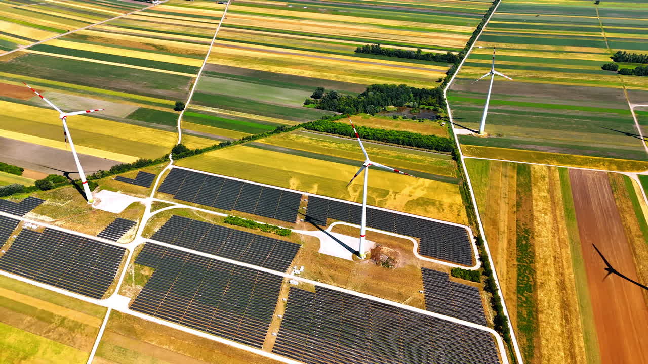 Fields with solar panels installed. Aerial perspective on the Wind turbines produce energy in the countryside